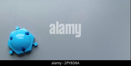 Blue mold from the children's designer on a gray background. Shiny plastic mosaic detail. Children's toy for the development of imagination and fine motor skills of hands Stock Photo