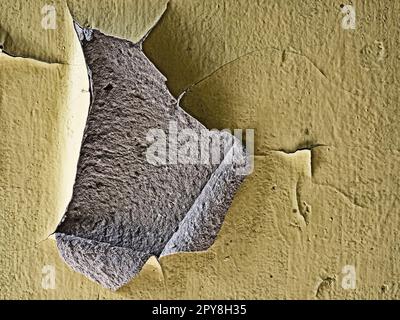 Close-up of piece of peeled paint from yellow painted wall Stock Photo
