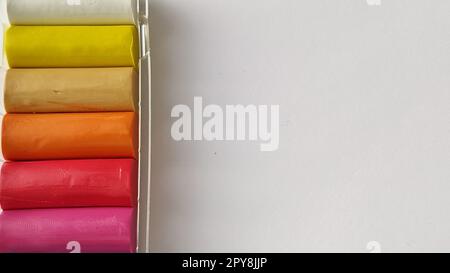 Multi-colored plasticine in plastic packaging on a white background Stock Photo