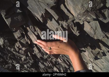Close up female hand touching basalt rock concept photo Stock Photo