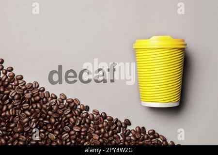 Word Decaf, coffee beans and takeaway paper cup on light grey background, flat lay Stock Photo