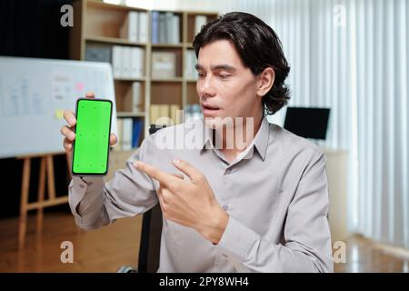 Startupper showing smartphone with application he developed on screen Stock Photo