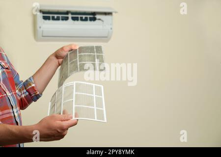 Man holding dirty and clean filters, space for text. Home air conditioner cleaning Stock Photo