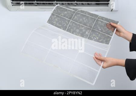 Woman holding dirty and clean filters, closeup. Home air conditioner cleaning Stock Photo