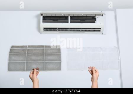 Woman holding dirty and clean filters, closeup. Home air conditioner cleaning Stock Photo