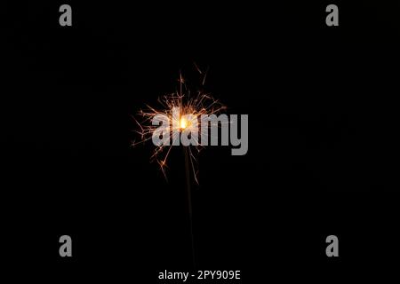 One burning sparkler stick on black background Stock Photo