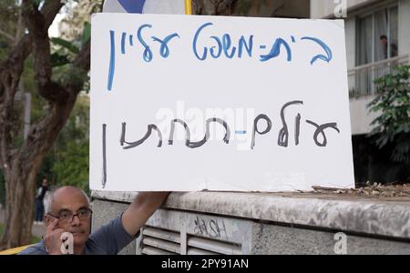 TEL AVIV, ISRAEL - APRIL 30: A right wing protestor holds a sign which reads 'Supreme Court, Underworld' during a demonstration held by reform supporters calling for the resumption of the judicial reform near the home of former High Court Justice president Aharon Barak who has been a vociferous critic of the Netanyahu government's judicial overhaul plan on April 30, 2023 in Tel Aviv, Israel. Stock Photo