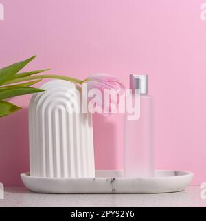 White plastic transparent bottle for liquid cosmetics on a pink background Stock Photo