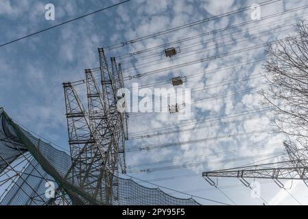 A newly installed high-voltage pylon with some cables connected Stock Photo