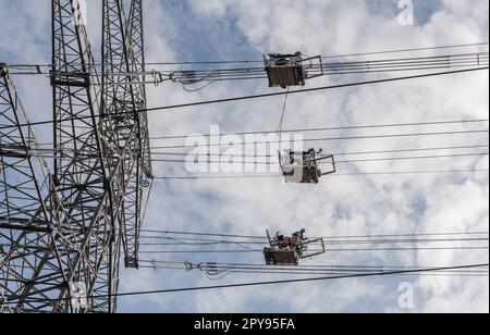 A newly installed high-voltage pylon with some cables connected Stock Photo