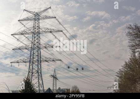 A newly installed high-voltage pylon with some cables connected Stock Photo