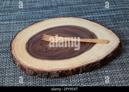 Wooden chopping board with growth rings and wooden fork Stock Photo