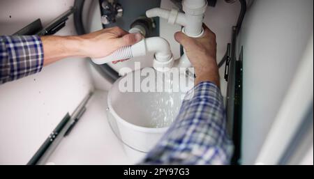 Plumber Fixing Pipe Leak Stock Photo