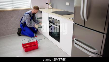 Plumber Drain Cleaning Services In Kitchen Stock Photo