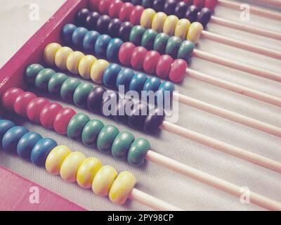 Education concept - abacus with many colorful beads. Red, blue, green, black, yellow details on the abacus. Mathematical exercises. School program Stock Photo