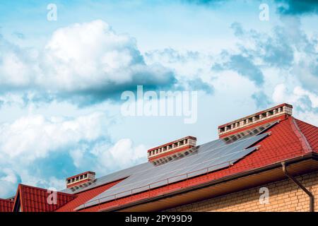 Photovoltaic or solar panels on a house with a red roof Stock Photo