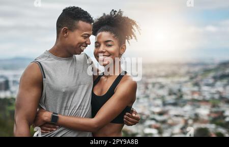 Nothings impossible with him by my side. an affectionate and athletic young couple standing with their arms around one another outdoors. Stock Photo