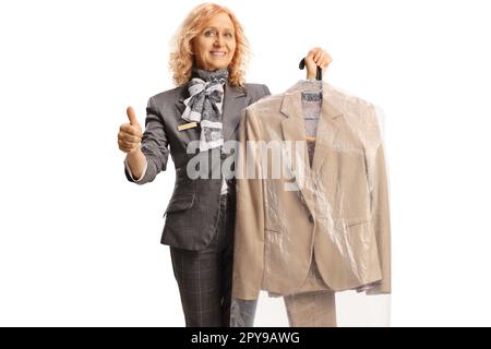 Woman holding a suit on a hanger with a case cover and gesturing thumbs up isolated on a white background Stock Photo