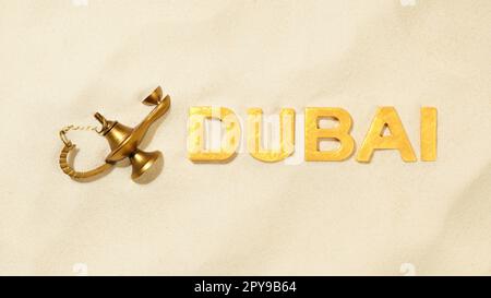 Dubai - Name of the city with old magical oil lamp in the sand Stock Photo