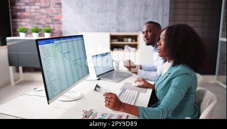 Young Businesspeople Analyzing Gantt Chart Stock Photo