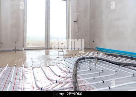 installation of concrete and anhydrite on underfloor heating in a room of a newly built family house Stock Photo