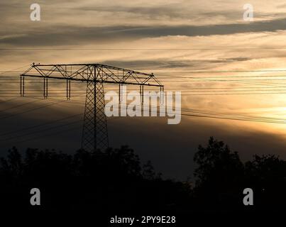 High-voltage power pole with overhead line through which the electricity is transported Stock Photo