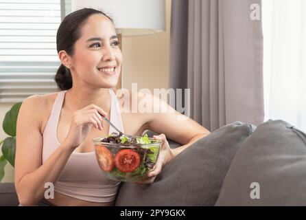 Smiling woman having healthy breakfast at home after yoga workout with happiness. Stock Photo