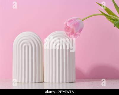 White ceramic decorative arch on a pink background, background for showcasing cosmetics, products, advertising and promotion. Stock Photo