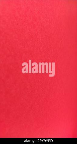 Beautiful vertical red bright background. Scarlet color. A rough sheet of colored paper with natural light. Fragment of a sheet of colored paper with a thin fleecy surface. Stock Photo