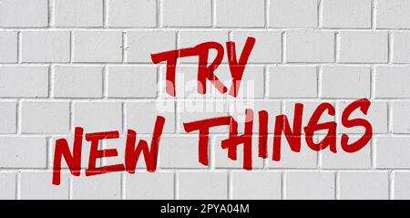 Graffiti on a brick wall - Try new things Stock Photo