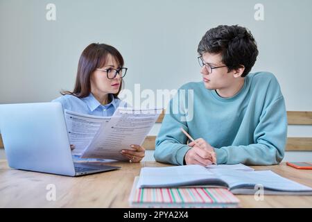 Young teenage male studying languages with teacher in classroom Stock Photo