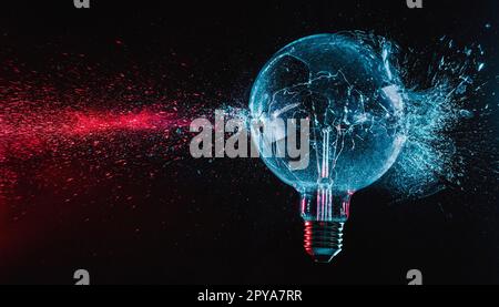 large blue bulb shatters and creates fragments of red glass. Stock Photo