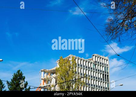 Background of process of demolition of building. Excavator breaking old house. Stock Photo