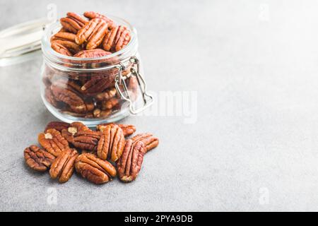 Peeled pecan nuts in jar on kitchen table. Stock Photo