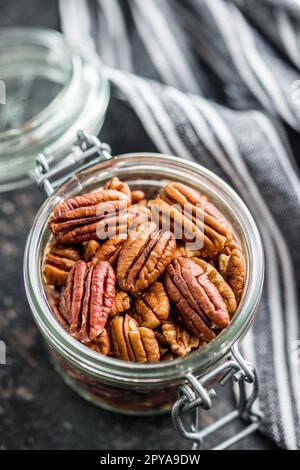 Peeled pecan nuts in jar on kitchen table. Stock Photo