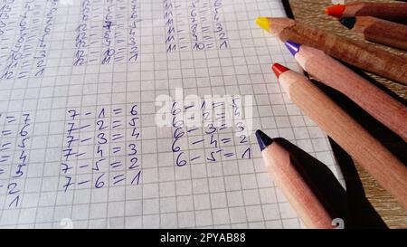 Examples of arithmetic problems are written on a sheet in a cell Stock Photo