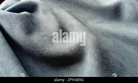 a velvety thick fabric for curtains of gray and blue color pleated with the play of chiaroscuro Stock Photo