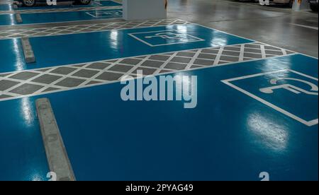 Car parking lot reserved for handicapped driver in supermarket or shopping mall. Car parking space for disabled people. Wheelchair sign paint on parking area. Blue and white handicapped parking lot. Stock Photo