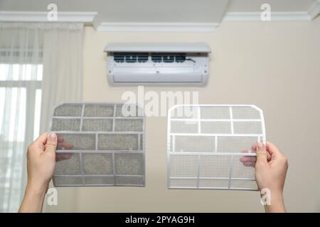 Man holding dirty and clean filters, closeup. Home air conditioner cleaning Stock Photo