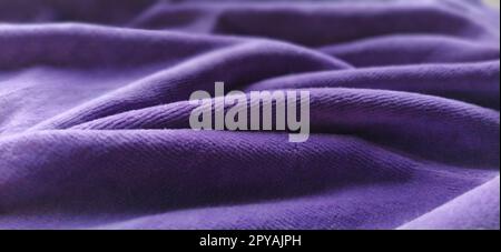 Fabric sheer curtain fabric. Beautiful violet color. Soft velvet with a pile. The curtain material is carelessly folded and wrinkled on a horizontal surface. Fabric sample. Interior design option. Stock Photo