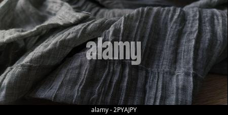 Gray pleated fabric or crumpled textile closeup. Light translucent curtains or tulle in the Scandinavian style. The lower edge of the curtain is hemmed 2-3 cm from the edge. Soft focus. Stock Photo