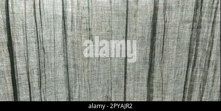 Gray pleated fabric or crumpled textile closeup. Light translucent curtains or tulle in the Scandinavian style. Soft focus. Pastel colors on the fabric. Stock Photo