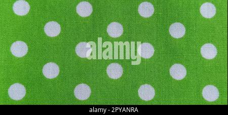 Belgrade, Serbia, 11 September 2020 Green fabric with polka dots. White circles. Close-up. Fabric for sewing dresses and home furnishings. Banner Stock Photo