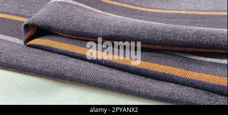 Light green and black-gray folded fabric with orange and dark blue stripes. Interior decoration. Dress fabrics in casual style. Dense material for indoor curtains and furniture finishing Stock Photo