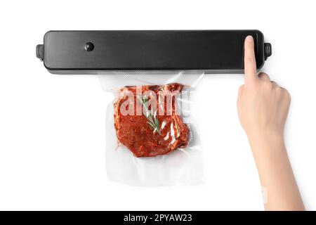 Woman using sealer for vacuum packing and plastic bag with meat steak, rosemary on white background Stock Photo