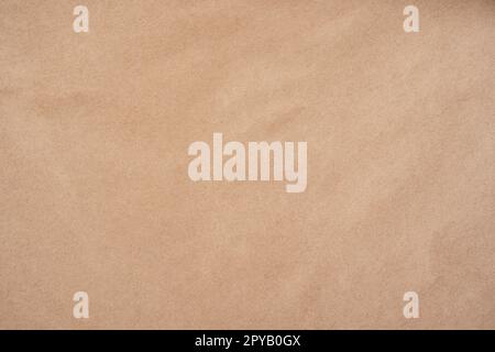 Background image of rough crumpled recycled textured kraft paper. Top view, copy space Stock Photo