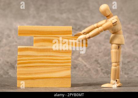 Dummy pulling out wood block from a tower Stock Photo