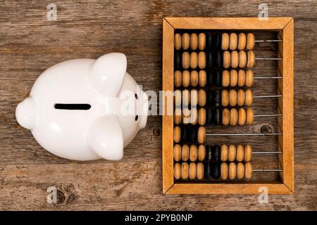 Ceramic piggy bank and old wooden abacus Stock Photo