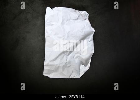 Crumbled paper top view close-up of crumpled sheet of white paper. Top view textured paper background, dark concrete texture. space for text Stock Photo