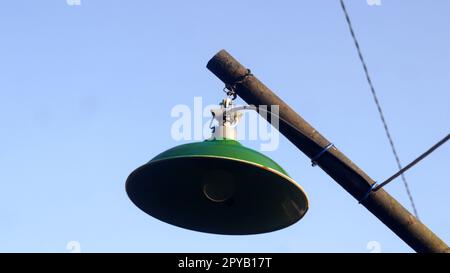 green street lights shot from below against a bright blue sky background Stock Photo